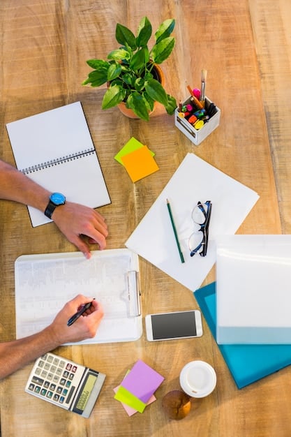 A person using a planner and color-coded schedules to allocate time for different activities. The setting is a well-lit workspace with various organizational tools.