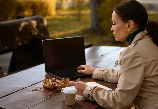 A person working on a laptop outdoors in a coffee shop, illustrating the flexibility and freedom associated with gig economy work. The environment is relaxed and informal.
