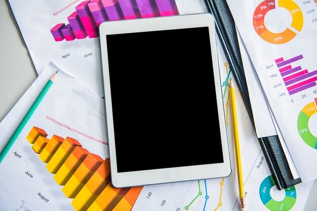 A close-up shot shows a tablet displaying a financial planning software interface with colorful charts and graphs. A stylus pen is hovering over the screen, suggesting interactive data analysis.