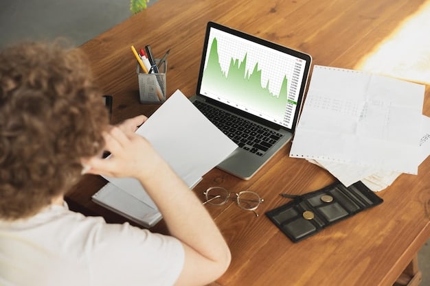 A freelancer's workspace with a laptop showing a dashboard view of a popular budgeting software. The screen displays graphs and charts illustrating income, expenses, and savings goals.