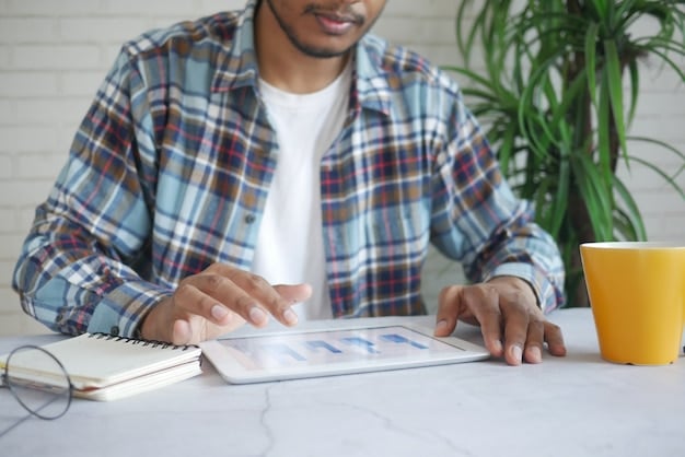 A freelancer sitting at a desk, using a budget planning app on their tablet. The screen displays a detailed breakdown of income and expenses with graphs showcasing financial trends.