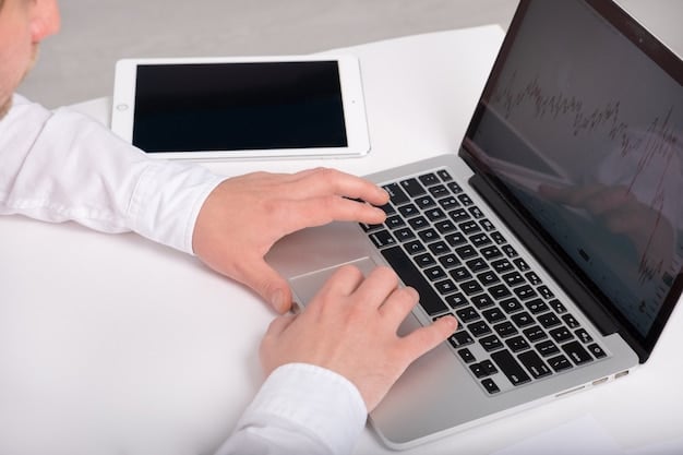 A close-up shot of hands typing on a laptop with a financial graph on the screen, reflecting data analysis and economic trends. The setting is bright and professional, suggesting a modern office environment.
