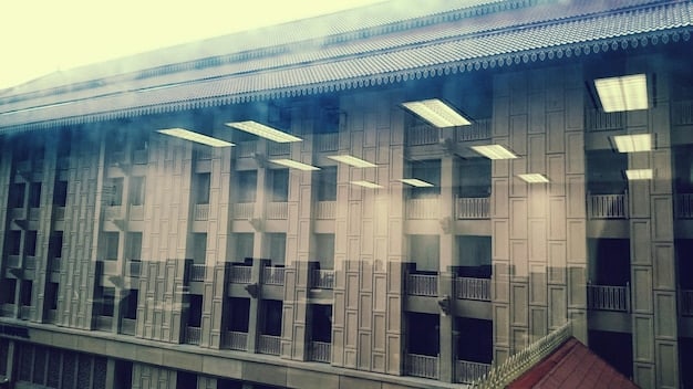 The Federal Reserve building in Washington D.C. with graphs superimposed showing both a rise in jobless claims and a decline in inflation, representing the complex data affecting monetary policy decisions.